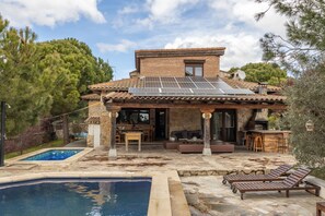 A house with a swimming pool, outdoor seating, and a solar panel roof. - Holiday Home 'El Berrueco' with Mountain View, Private Pool and Wi-Fi (El Berrueco)