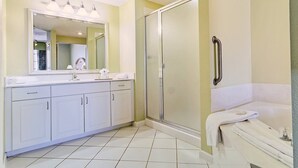 Un baño moderno con ducha a nivel, un espejo grande y una bañera.