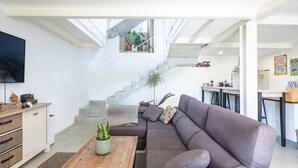 Un salon moderne avec un grand canapé, une table basse en bois et un téléviseur.