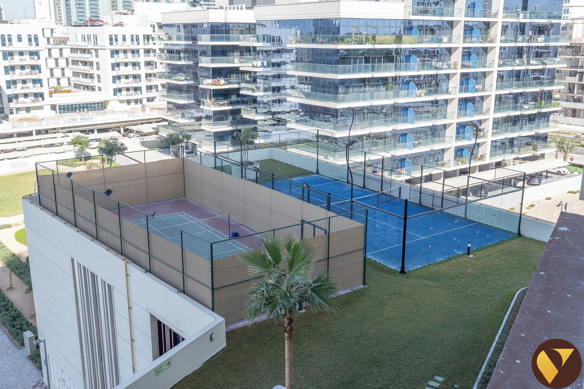 A multi-story residential building with a rooftop tennis court and a swimming pool.