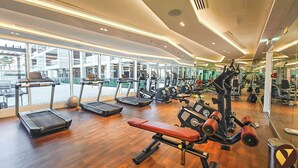 Ein geräumiges Fitnessstudio mit Laufbändern, Kraftgeräten und Trainingsbällen.