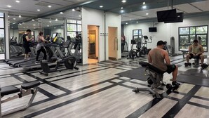 A gym with treadmills, stationary bikes, and weight machines. - 1BR Condo w/ Great View Near Venice Canal & BGC  (Taguig)