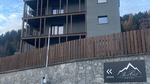 A multi-story hotel with a stone facade and a wooden fence. - Condhotel Fanti Ski & Bike (Valdisotto)