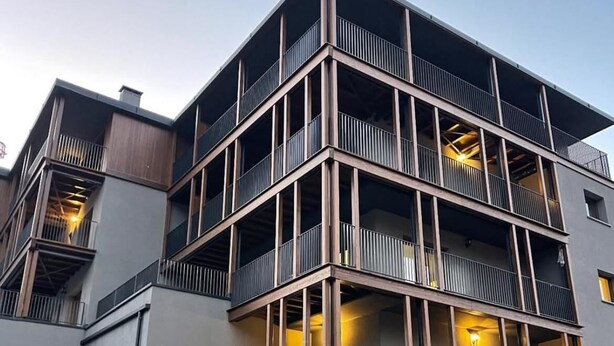 A multi-story building with balconies, a stone facade, and a gated entrance. - Condhotel Fanti Ski & Bike (Valdisotto)