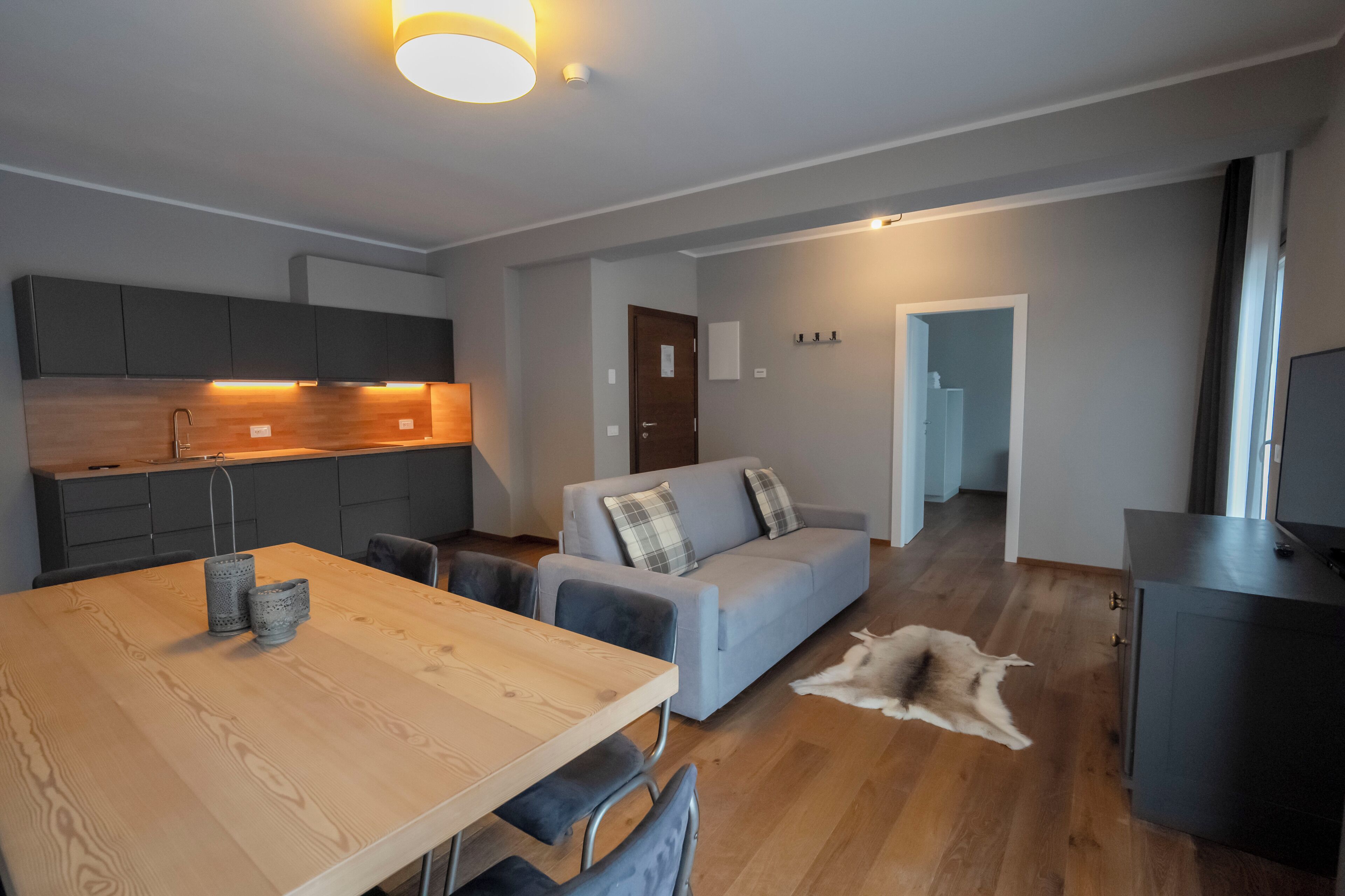 Un interior moderno con una mesa de comedor, sofá y área de cocina.