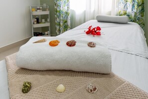 A neatly made bed with a white towel and four seashells on a beige mat. - Charming 3-bedroom house with AC and WiFi in Quepos (Quepos)