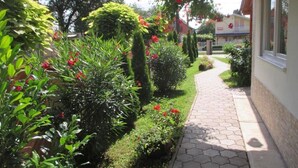 A garden pathway leading to a building with a tiled entrance. - Riviera Apartment Family Apartments near the swimming pool and aquapark! (Hajdúszoboszló)