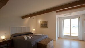 A bedroom with a bed, bedside lamps, a wooden bench, a painting, and a large window with a view. - Villa le statue is 5 km from the center of Florence, pool and private parking (Firenze)