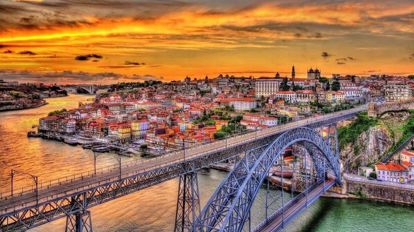 A bridge spanning a river with a cityscape in the background.