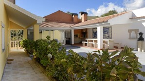 A courtyard with a patio area, a dining table, and a garden with various plants.