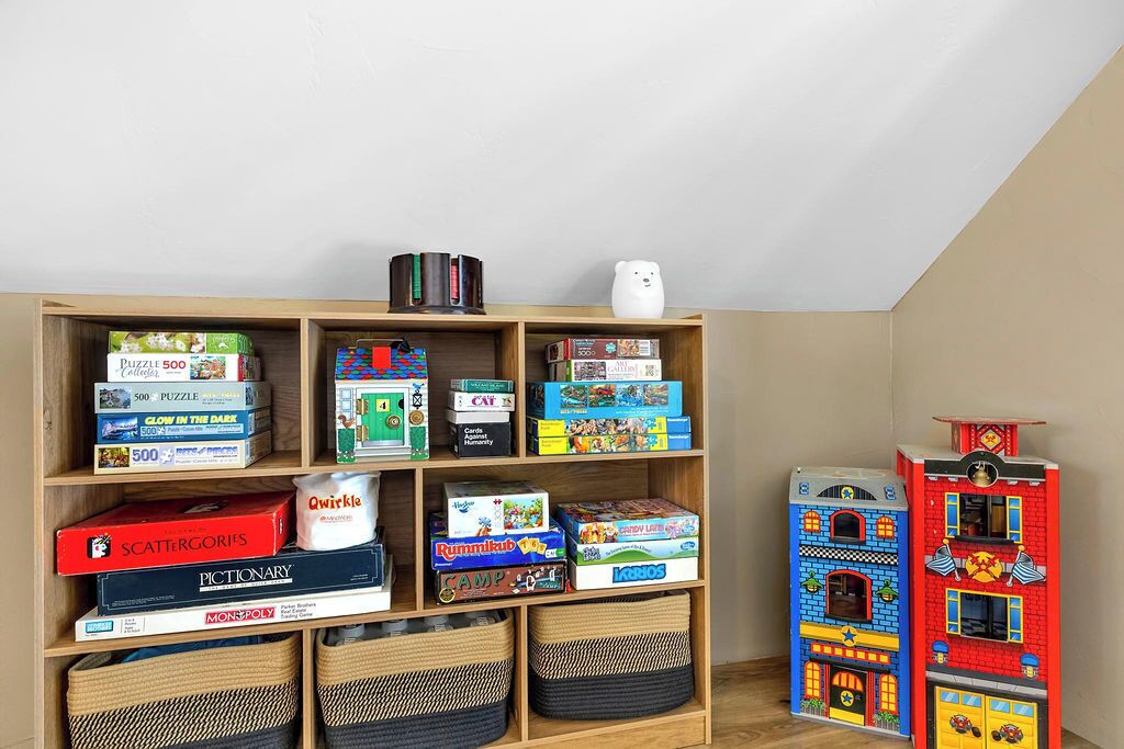 A room with a wooden bookshelf filled with various board games and puzzles.