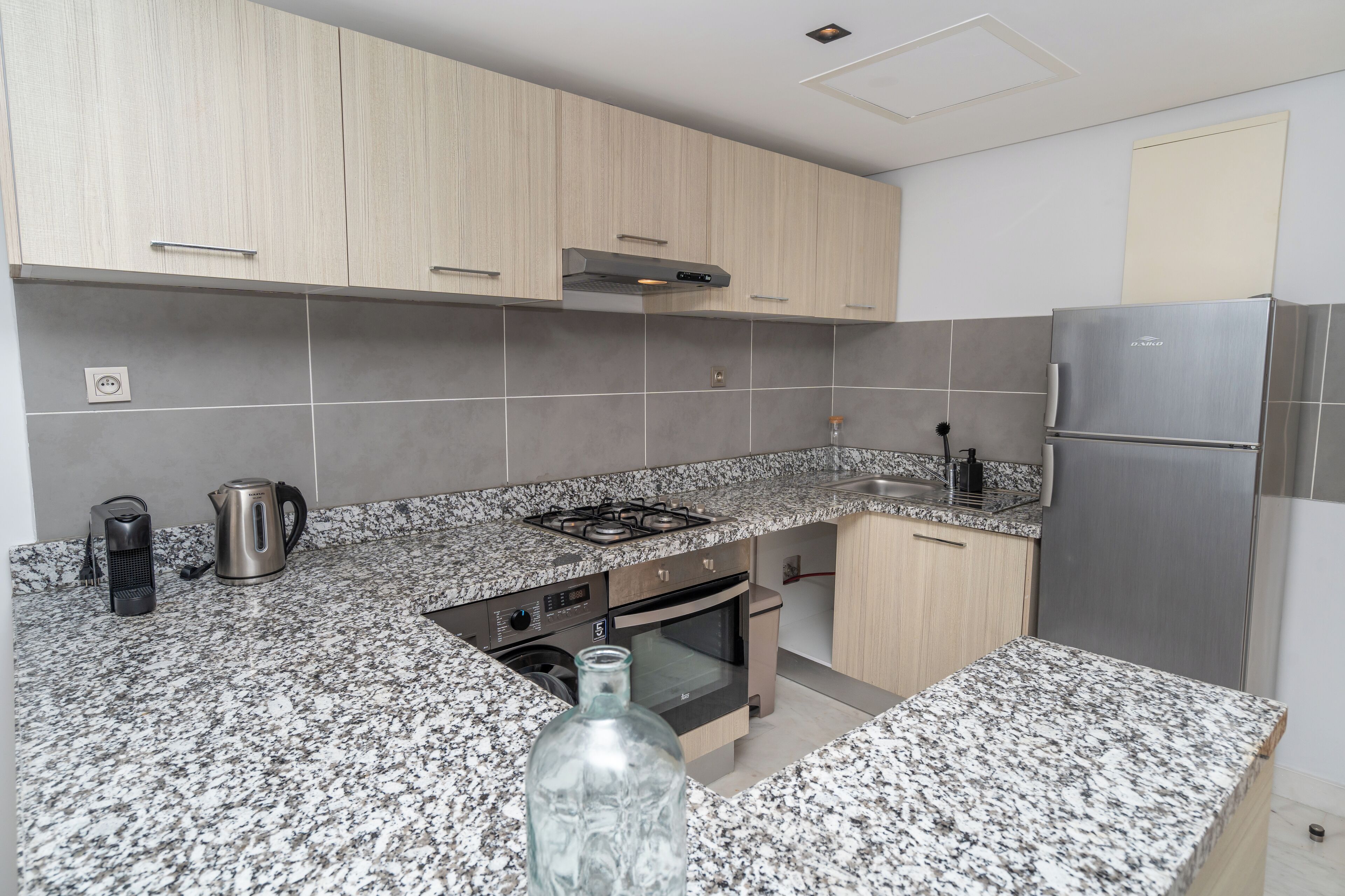 A modern kitchen with granite countertops, stainless steel appliances, and wooden cabinets.