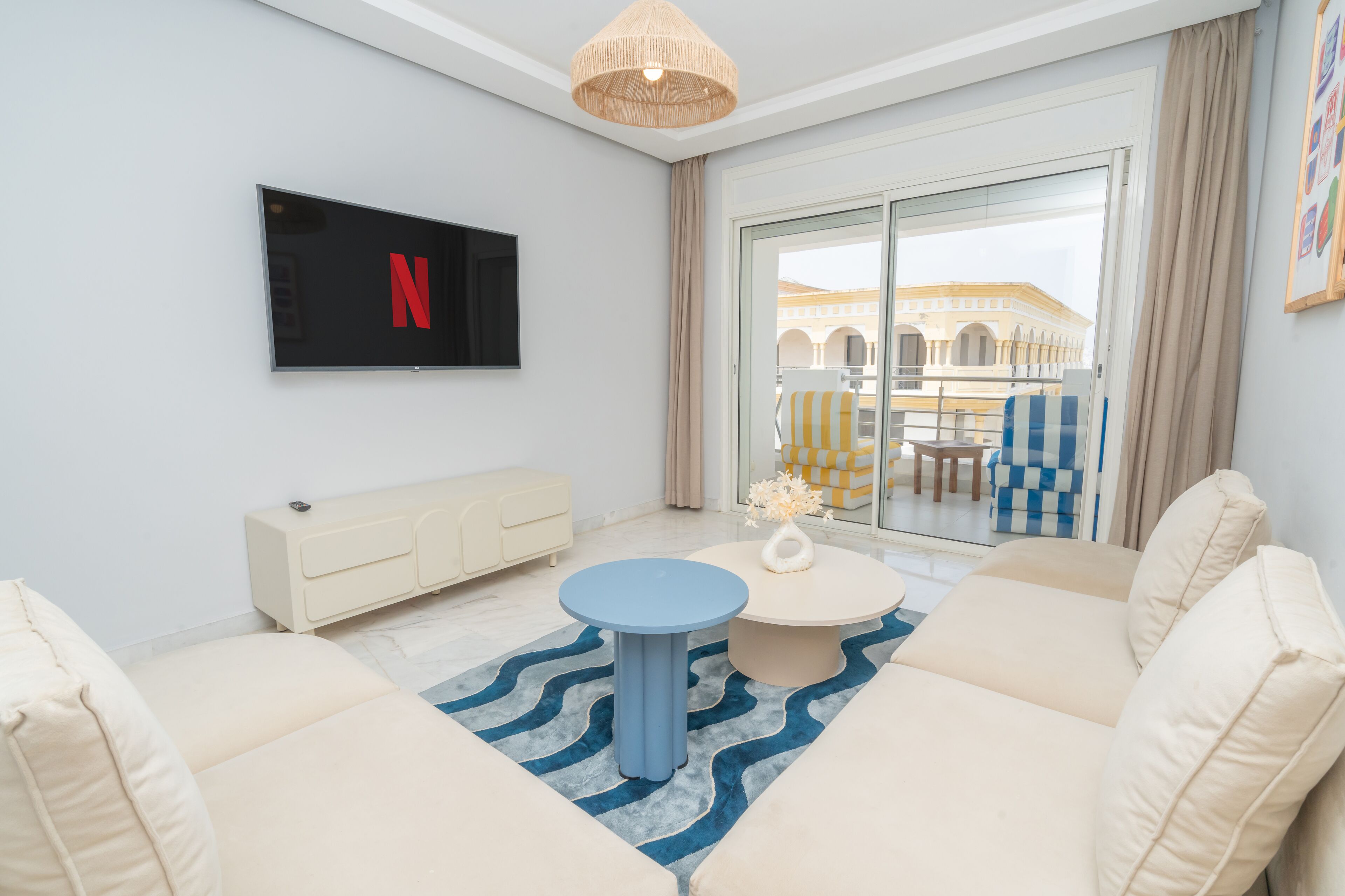 A modern living room with a flat-screen TV, a round coffee table, and a sofa.