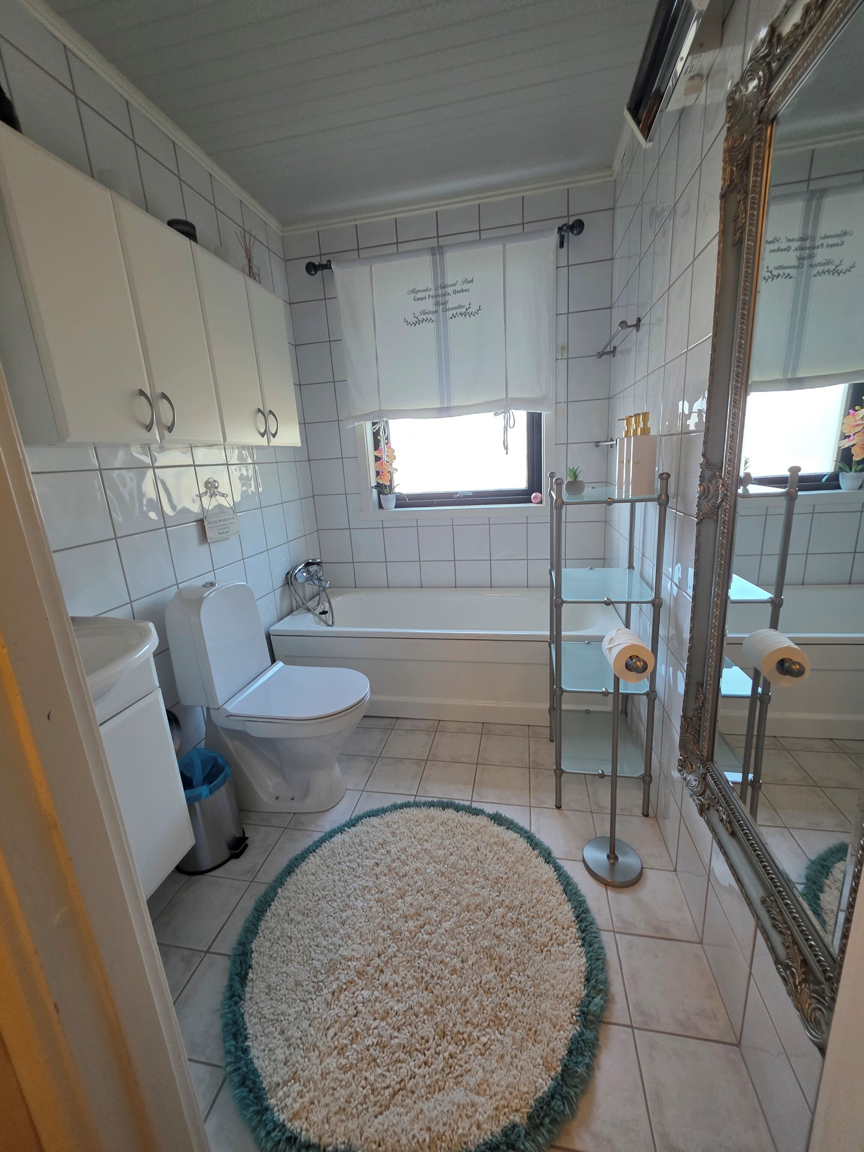 Un baño con inodoro, lavamanos, bañera y un espejo grande.