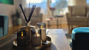 A room with a wooden table, candles, and a bottle of perfume. - La Casa Senja Seaview Villa with Sauna (Troms)