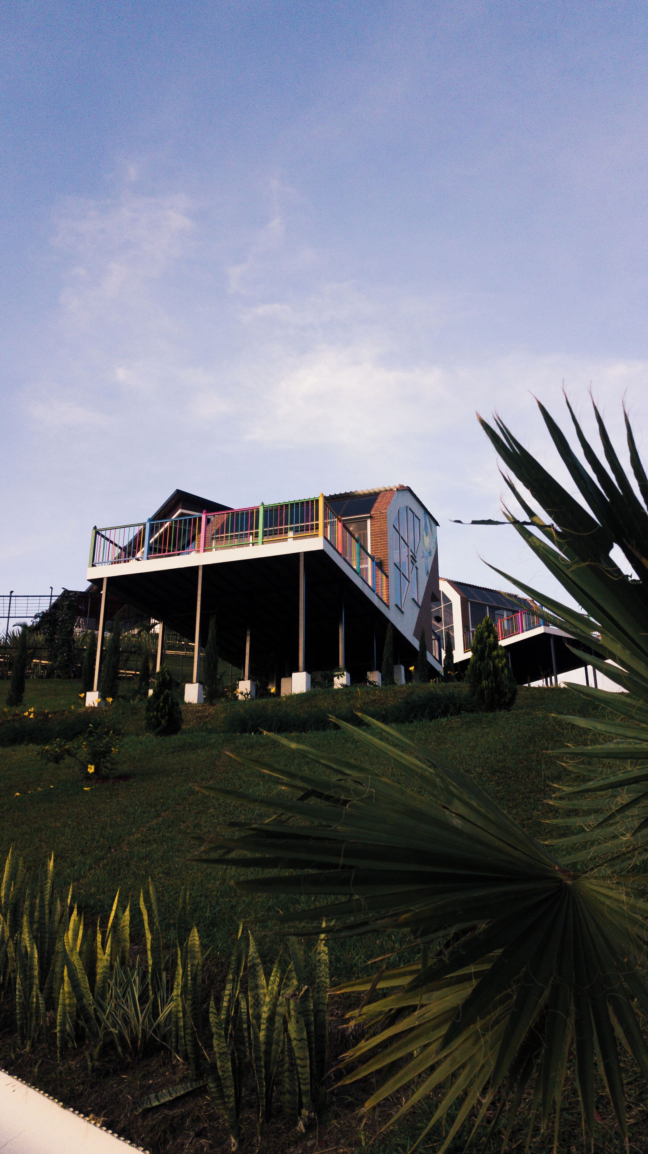 A modern house with a unique architectural design, featuring a multi-level structure and a prominent staircase.