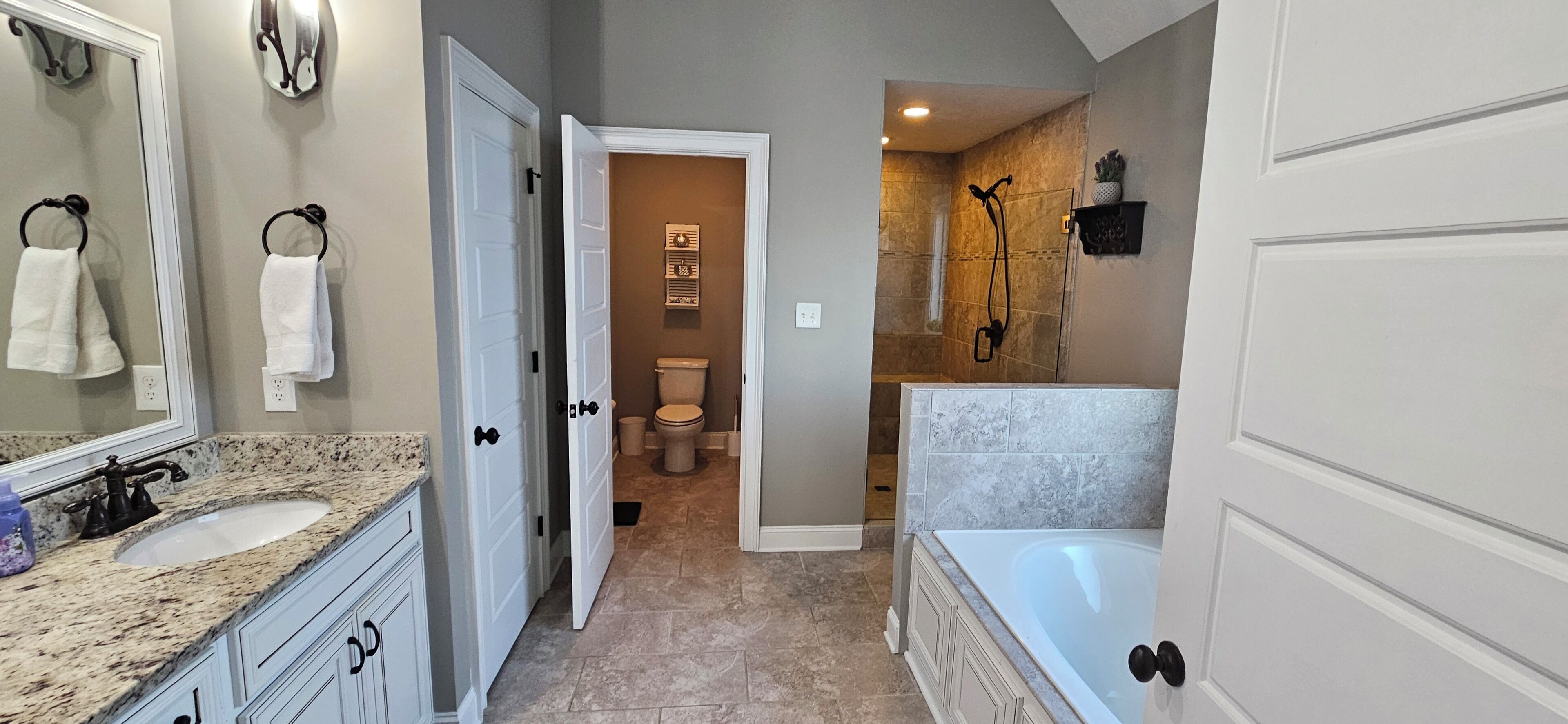 A modern bathroom with a sink, mirror, and bathtub.