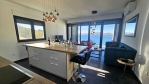 Eine moderne Küche mit Kochinsel, Barhocker und Meerblick.
