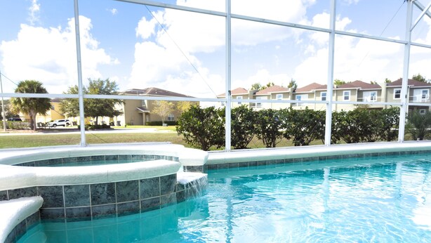 A swimming pool with a clear view of the surrounding residential area and a large window.