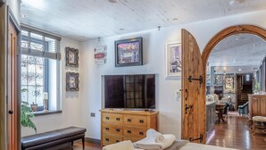 A room with a bed, a TV, wooden furniture, and a bench. - The Catacombs-barbican - Pet Friendly - 5 Guests (Plymouth)