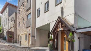 A cobblestone street with buildings, a stone facade, and a wooden entrance with plants. - The Catacombs-barbican - Pet Friendly - 5 Guests (Plymouth)