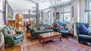 A spacious living room with leather sofas, a wooden coffee table, and a patterned rug. - The Catacombs-barbican - Pet Friendly - 5 Guests (Plymouth)