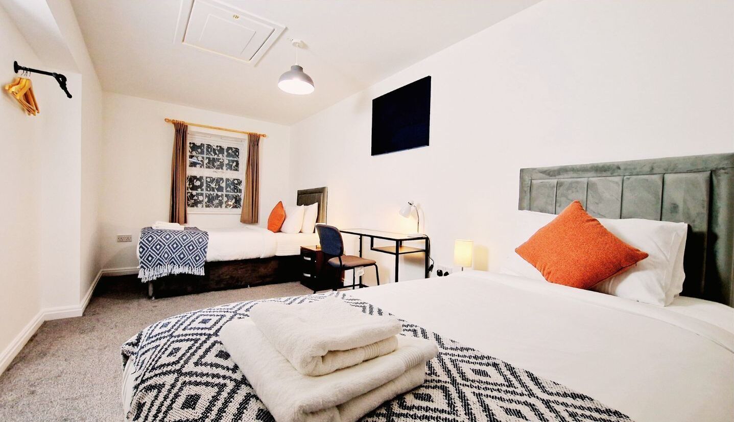 Een hotelkamer met een groot bed, een bureau, een stoel en een televisie.