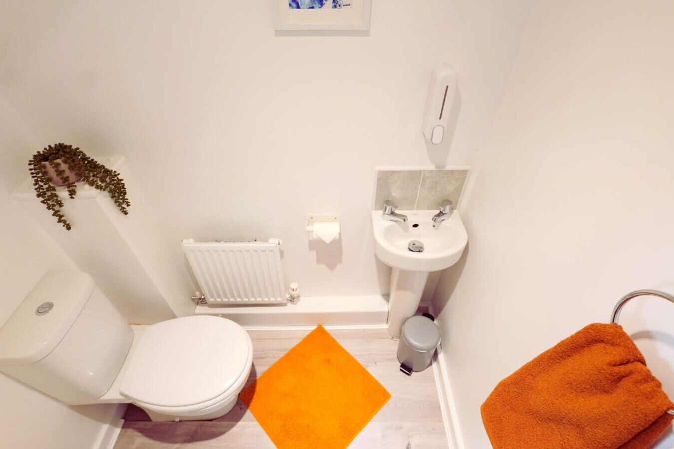Ein kleines Badezimmer mit Toilette, Waschbecken und Heizkörper.