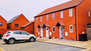 A row of red brick houses with a white car parked in front. - Barn Fold House with Parking, Garden, Wi-Fi (Telford and Wrekin)