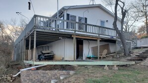 A house with a covered porch, a garage, and a tree in the yard. - Beautiful view on lake! Enjoy 5bdrm 3 bath with 2 decks firepit and private dock (Edwards)