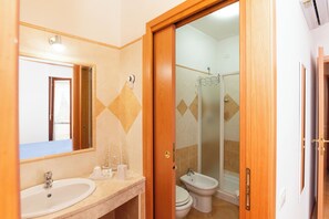 Une salle de bain avec un lavabo, des toilettes et une douche.