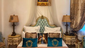 A bedroom with a four-poster bed, ornate headboard, decorative pillows, and a framed painting above the bed. - Conacul Coroanei Luxury Boutique (Bucharest)