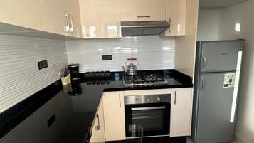 Een koelkast, een oven, een kookplaat, een koffiezetapparaat/waterkoker