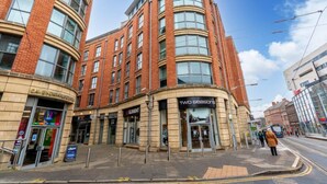 A multi-story building with a curved facade, featuring storefronts including 'Cavendish House' and 'Two Seasons'.