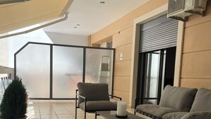 A balcony with a sofa, chairs, a table, and potted plants. - Wonderful central apartment with private parking space. (Larisa)