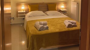 A well-lit hotel room with a bed, bedside lamps, and a ceiling light. - Wonderful central apartment with private parking space. (Larisa)