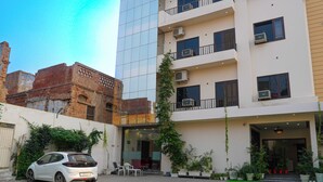 Un edificio moderno con diversi balconi, posti a sedere all'aperto e piante in vaso.
