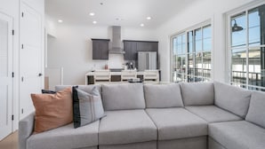 Una cocina moderna con armarios blancos, un refrigerador de acero inoxidable y un ventanal con vistas al exterior.