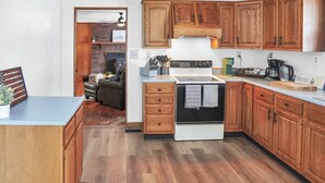A kitchen with wooden cabinets, a white stove, and a coffee maker on the counter. - Two bedroom  in United States of America, Summersville (Summersville)