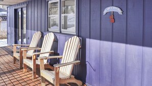 A covered porch with three wooden Adirondack chairs and a metal sign on the wall. - Two bedroom  in United States of America, Summersville (Summersville)