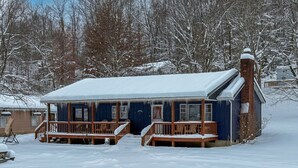 A snow-covered building with a wooden deck and a brick chimney. - Two bedroom  in United States of America, Summersville (Summersville)