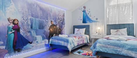 A bedroom with two beds, a large wall mural, and LED strip lighting.