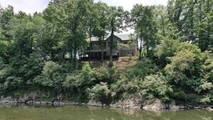 A lakeside cabin surrounded by dense trees. - Spacious Retreat on Caddo River, Amity (Amity)