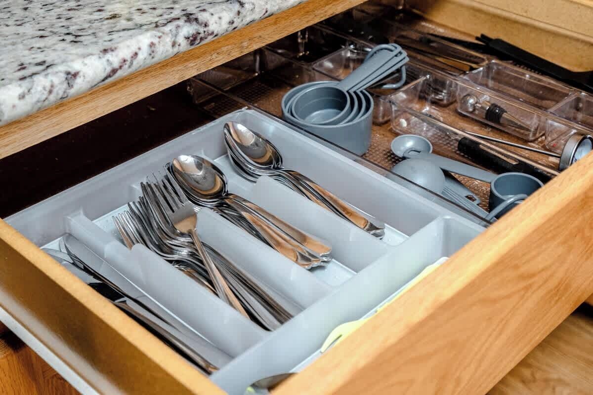 A drawer with utensils and kitchenware.