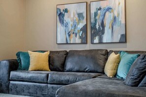 A dark leather sofa with multiple cushions in a living room.