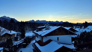 A residential area with snow-covered houses and a mountain range in the background.