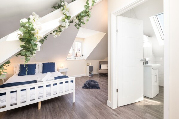 Relax in a clean and minimalistic bedroom with a loft-style design, featuring a comfortable bed and a bedside table.