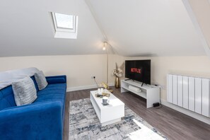 Relax in this cozy living space with a comfortable sofa, coffee table, and flat-screen TV.