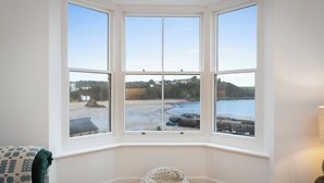 A bay window with a view of a beach and sea.