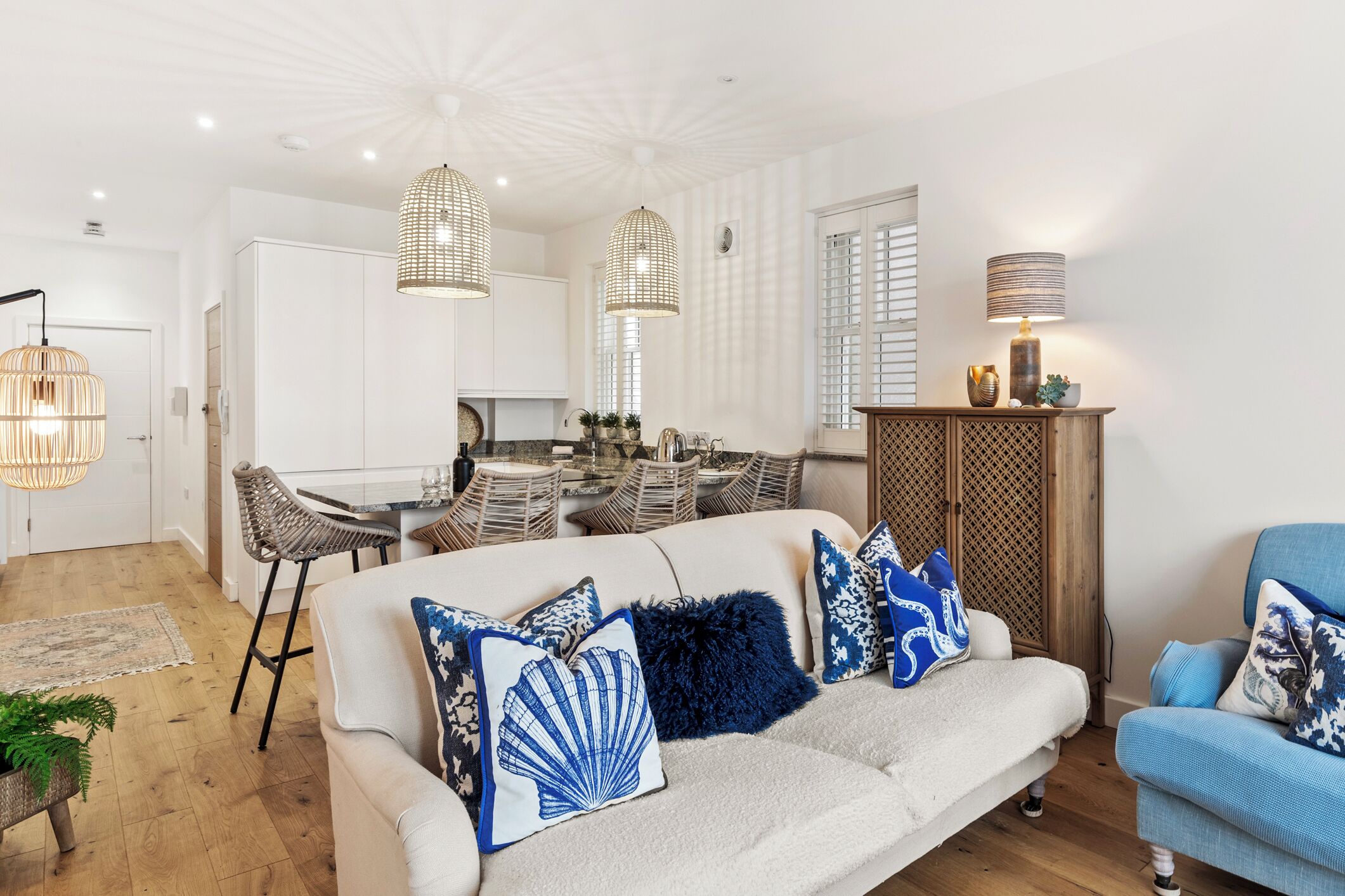 A modern living room with a sofa, armchairs, and a dining area.